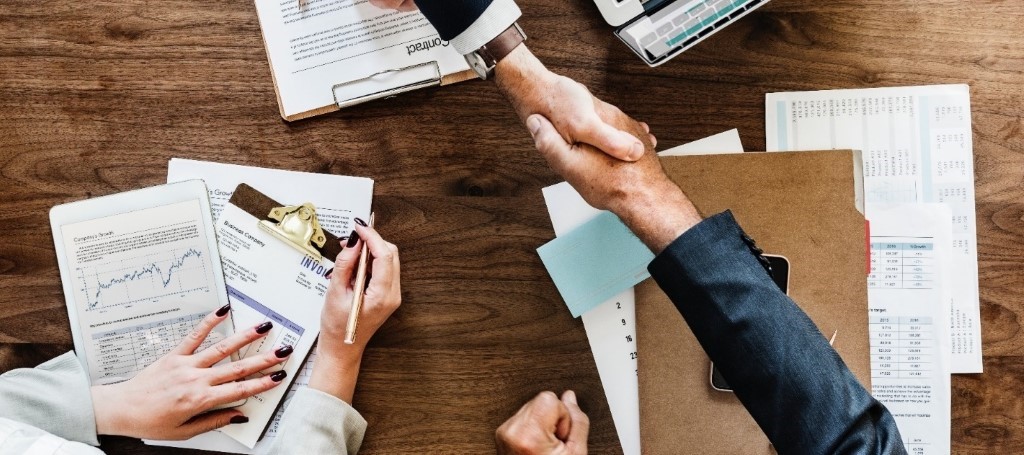 Overhead view of hands shaking over a business papers